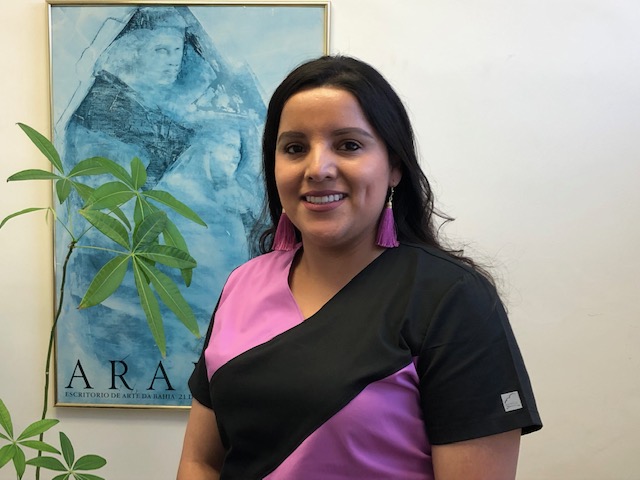Staff member in pink and black scrubs smiling in the office
