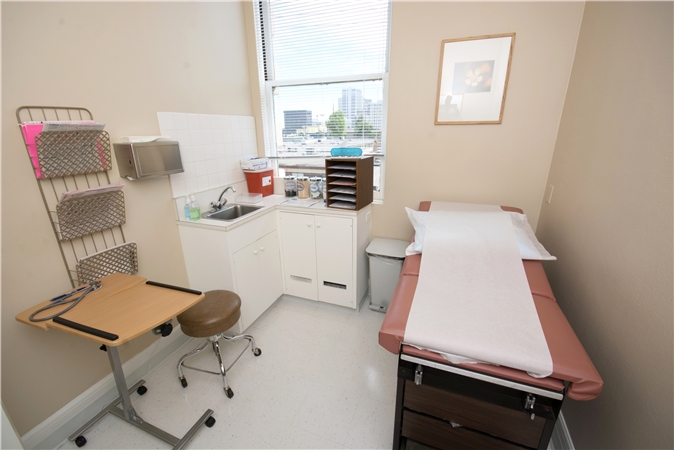 Patient room with exam bed and window view of Oakland