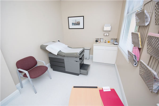 Bright exam room with patient chair and exam table